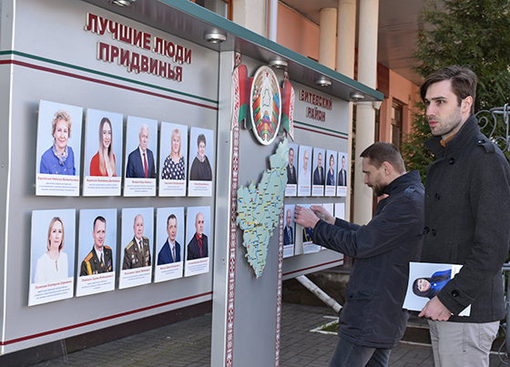 На снимке: ведется работа по обновлению доски Почета.