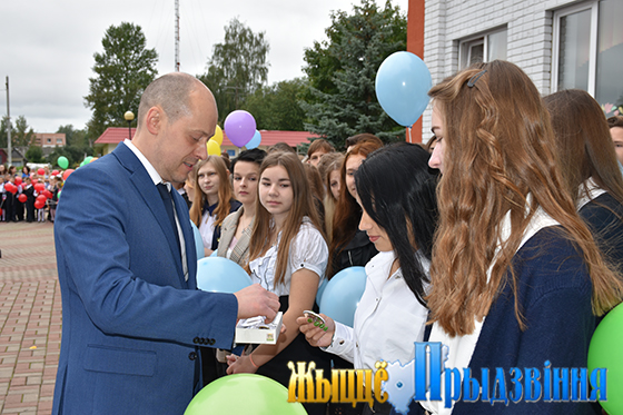 Алексей Ларькин вручает десятиклассникам отличительные значки